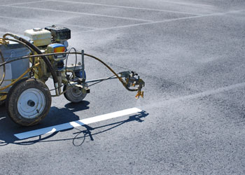 Striping machine applying pavement markings